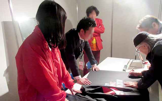 サインを書く松本零士先生とサポートする藤田さん等