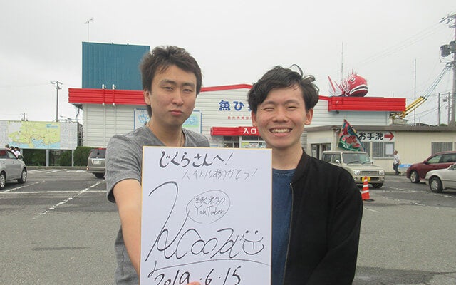 きまぐれクックさんとサイン色紙と共に写る藤倉さん